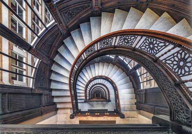A stair hall lit from above inside an older city building