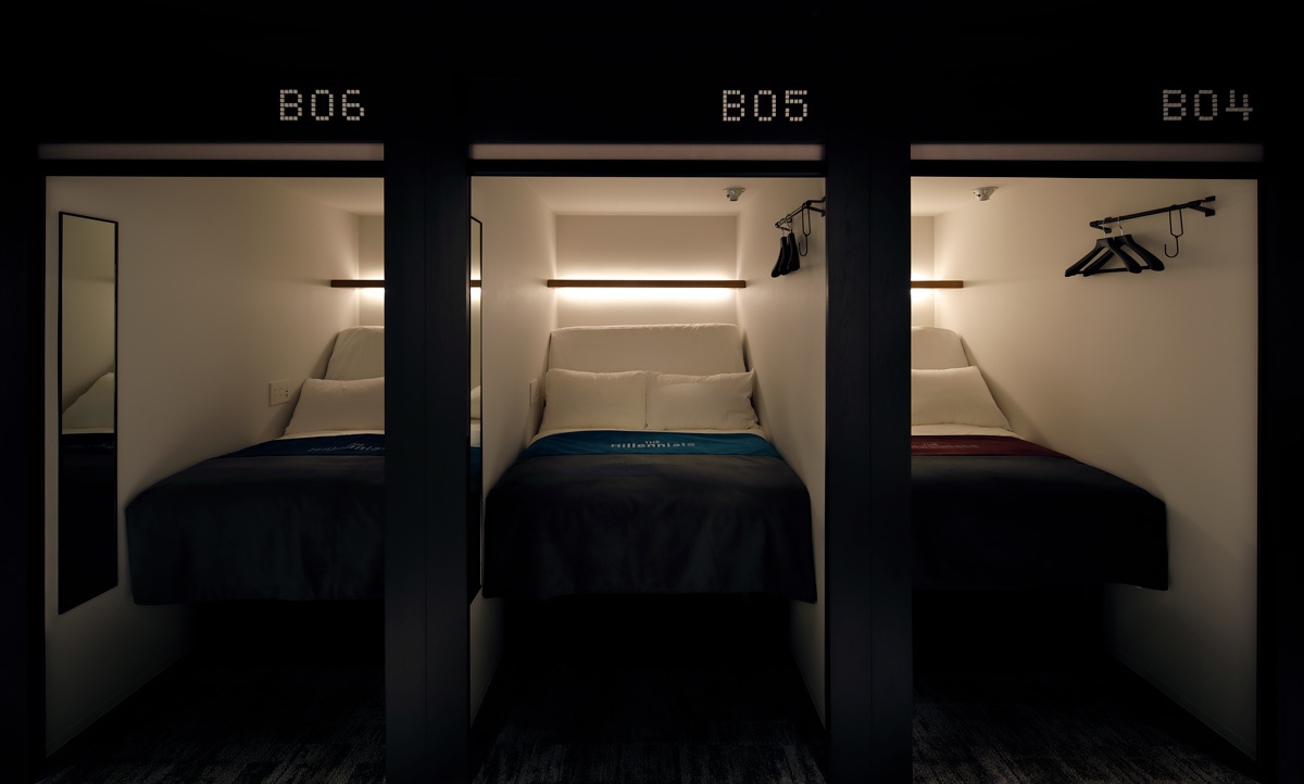 Two tiers of enclosed sleeping berths along a narrow lit corridor
