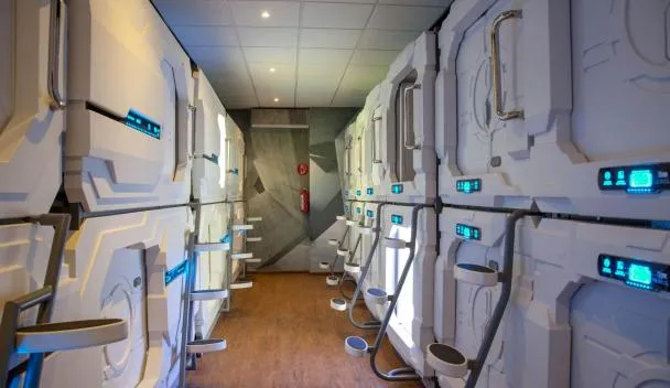 A row of small sleeping cabins with numbered doors inside a terminal